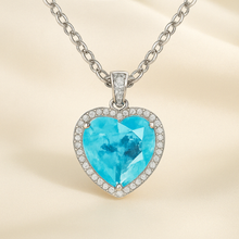 “Curación Holística exclusive heart-shaped Paraiba Tourmaline sterling silver statement necklace on a satin background – vibrant electric blue gemstone surrounded by pavé-set crystals.”