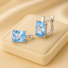 Light blue aquamarine earrings captured in soft luxury lighting