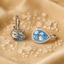 Earrings placed on satin background with white quartz scattered for luxury detail