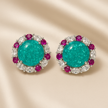 Close-up of Paraiba tourmaline earrings in sterling silver with white quartz and rubies