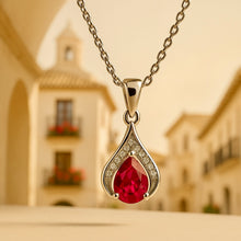 “Elegant ruby and white quartz teardrop pendant necklace photographed in a Spanish village atmosphere.”