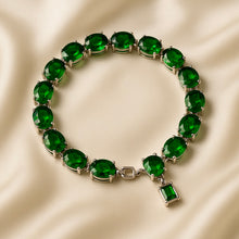 Sterling silver statement bracelet with green glass-filled gemstones.