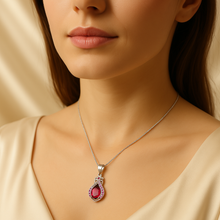 “Hand presenting the ruby pendant necklace highlighting its vibrant sparkle and gold finish.”