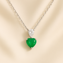 “Close-up of a luxurious sterling silver necklace with green nano-emerald and clear white quartz gemstones, symbolizing healing and love, exclusive to Curación Holística.”
