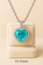 “Curación Holística exclusive heart-shaped Paraiba Tourmaline sterling silver statement necklace on a satin background – vibrant electric blue gemstone surrounded by pavé-set crystals.”