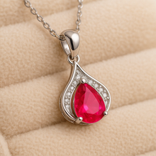 Close-up of handcrafted ruby pendant necklace with sparkling white quartz accents on gold-plated sterling silver.”