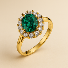 Oval nano emerald halo ring in gold on cream jewelry box