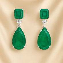 	Statement emerald and quartz earrings with luxury lighting and shadow