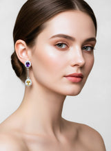 Woman wearing elegant earrings on a plain background