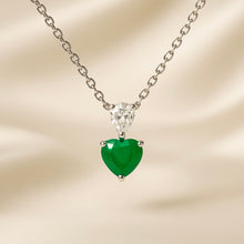 Handmade sterling silver necklace featuring a heart-shaped natural nano-emerald and pear-cut white quartz pendant by Curación Holística, showcased against a sunlit Spanish courtyard.”