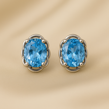 •	Aquamarine sterling silver handmade stud earrings on luxury satin background