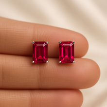 Petite ruby stud earrings displayed on elegant jewelry packaging