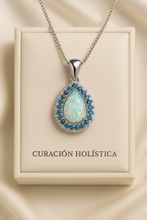 “Close-up of Curación Holística’s exclusive white opal pendant surrounded by aquamarine stones.”