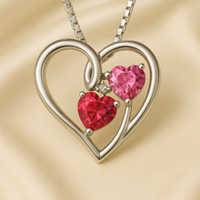 	“Romantic ruby red and rose topaz heart necklace on luxury cream satin background.”