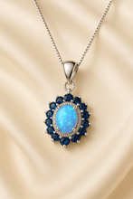 “Handmade opal and sapphire halo necklace set in sterling silver, radiating healing energy and timeless elegance.”