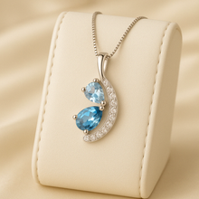 Aquamarine and London blue topaz pendant necklace on satin background
