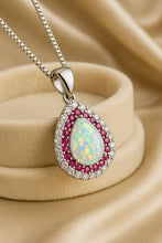 “Fire opal and ruby halo necklace by Curación Holística shown on model, showcasing its luxurious elegance and spiritual charm.”