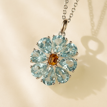 Close-up of aquamarine necklace with vibrant orange citrine centerpiece.