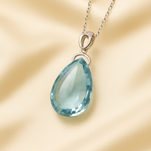 Close-up of handcrafted aquamarine necklace with pear-cut stone