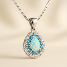 “Handmade white opal and aquamarine halo necklace in sterling silver, designed for healing and elegance.”