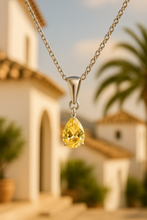 Close-up of Yellow Citrine Pendant on Cream Satin Background”