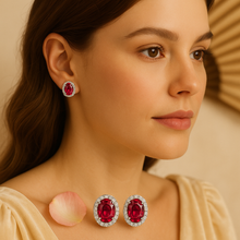 Hand holding Curación Holística ruby stud earrings highlighting size and luxurious shine.”