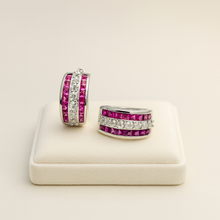 “Close-up of ruby rose quartz earrings on a cream display box”