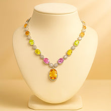 	Luxury necklace featuring citrine, peridot, and rose quartz on jewelry bust.