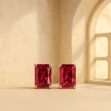 Close-up of rectangular-cut ruby gemstone earrings in silver setting