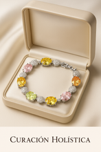 Luxury multi-stone sterling silver healing bracelet by Curación Holística featuring yellow, pink, green, and orange gemstones on a satin cream background with Spanish villa backdrop.

