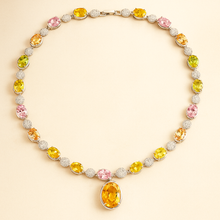 Close-up of healing gemstones: rose quartz, peridot, and citrine in sterling setting.