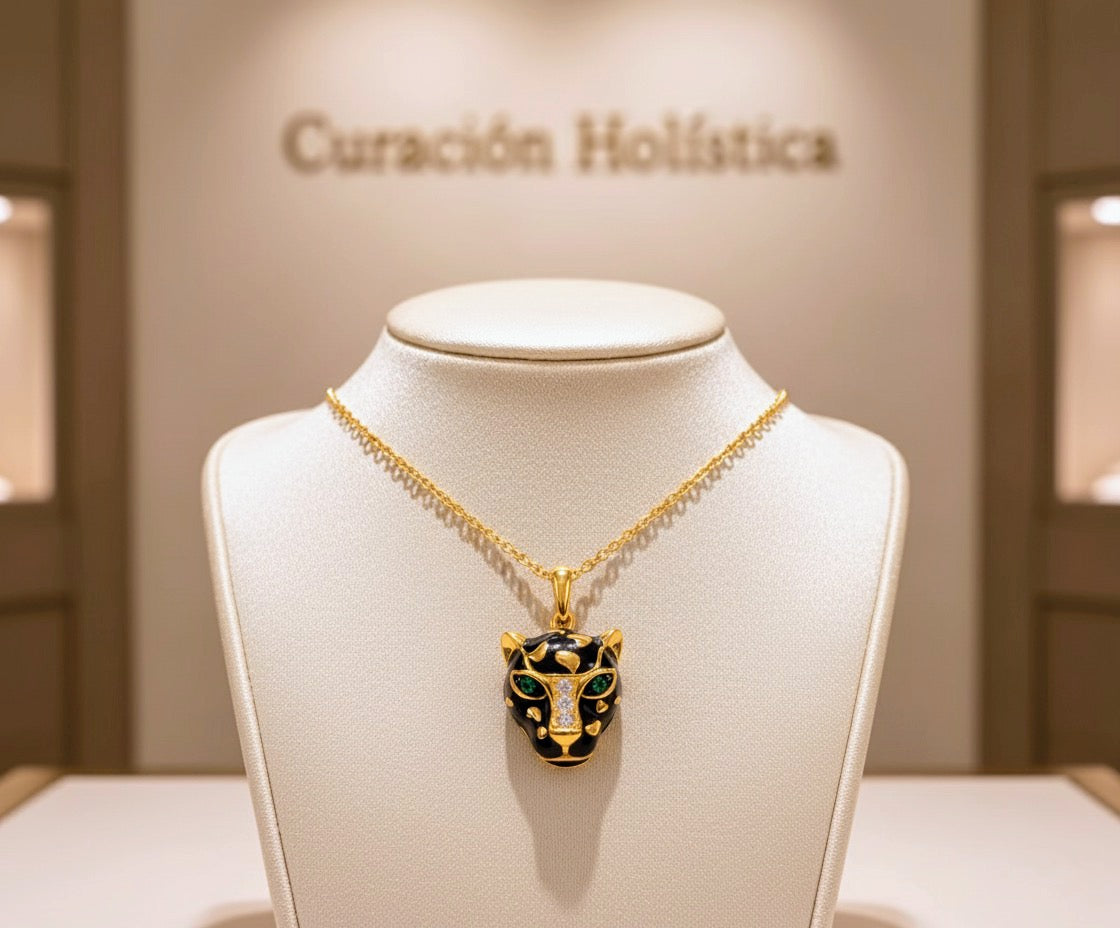 Gold necklace with a black and green pendant on a mannequin bust in front of a 'Curación Holástica' sign.