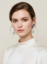 Woman wearing earrings with a neutral background