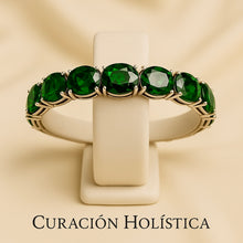 Handmade nano emerald bracelet on cream velvet jewelry stand.