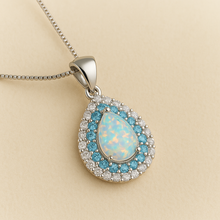 “Elegant sterling silver necklace with shimmering white opal and natural aquamarine halo.”