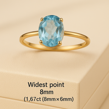 Elegant aquamarine ring on satin cream luxury background – close-up