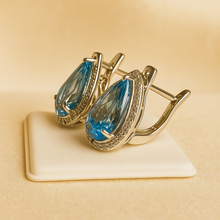 Side view of earrings showing lever-back clasp and gemstone depth