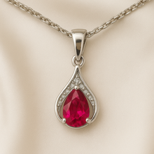 Boho chic ruby necklace glowing against a luxury cream satin background.”