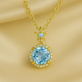 “Elegant gold-plated sterling silver necklace featuring a radiant aquamarine gemstone surrounded by a delicate halo of sparkling stones, displayed on a luxurious cream satin background.”
