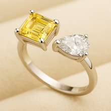 “Handmade adjustable sterling silver ring featuring an emerald-cut citrine and a pear-shaped white quartz by Curación Holística, showcased against a soft cream velvet background.”
