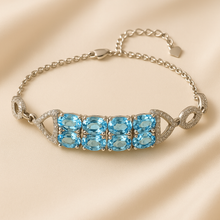 “Handmade aquamarine and sterling silver bracelet with white quartz accents, displayed elegantly on a cream jewelry box – exclusive artisan jewelry by Curación Holística.”