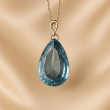Elegant aquamarine jewelry piece with soft lighting and reflection