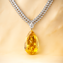 “Close-up of faceted citrine teardrop pendant with white quartz detail”