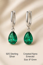 Side angle showing pear-cut nano emerald in luxury prong setting