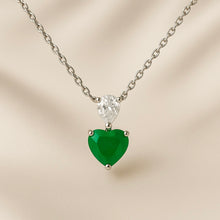 “Artisan-designed sterling silver necklace featuring a vivid green nano-emerald heart and white quartz, representing renewal and clarity, luxury jewelry from Curación Holística.”