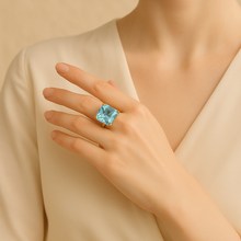 Big blue gemstone ring on a woman’s hand, elegant style.