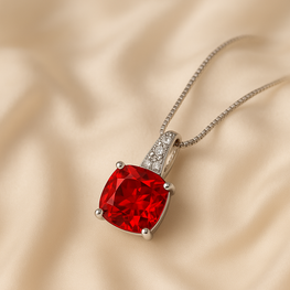 Close-up of gold-plated sterling silver ruby necklace with white quartz accents.”
