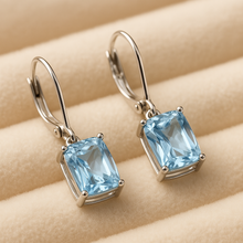 Earrings displayed on a jewelry stand with neutral background