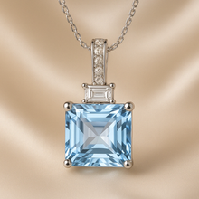 Aquamarine and white quartz pendant on satin background
