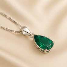 Close-up of boho style emerald necklace on luxury jewelry bust.